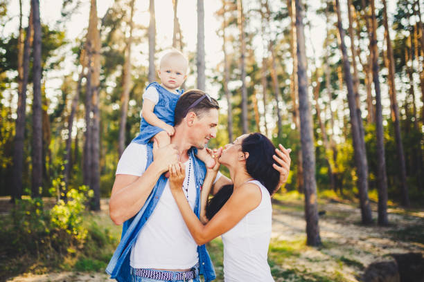 Happy couple sharing a kiss while holding their child, showing the balance between marriage and parenting