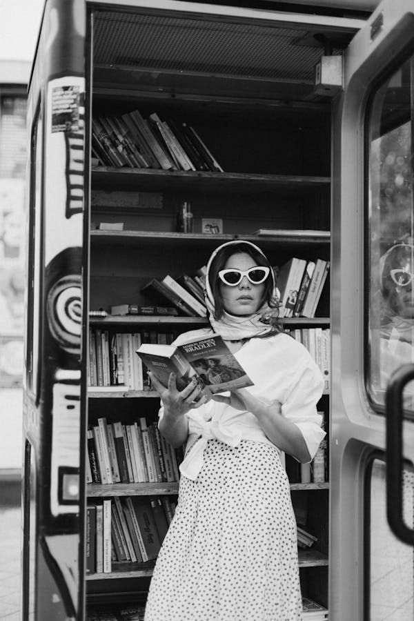 Woman in a retro outfit with a scarf, cat-eye sunglasses, and polka-dot skirt, symbolizing vintage fashion trends inspired by The Crown